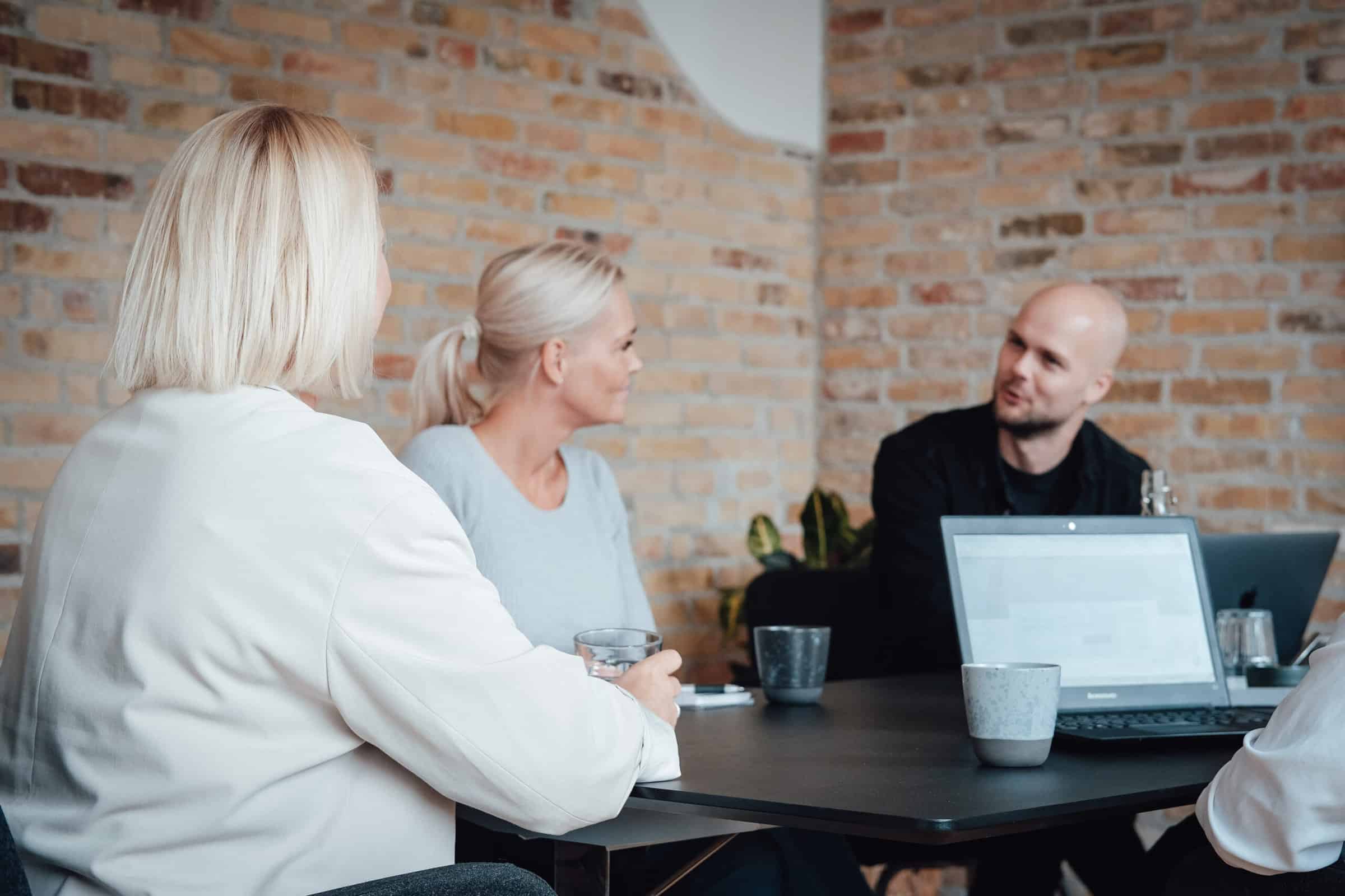 Three colleagues in conversation at the meeting table