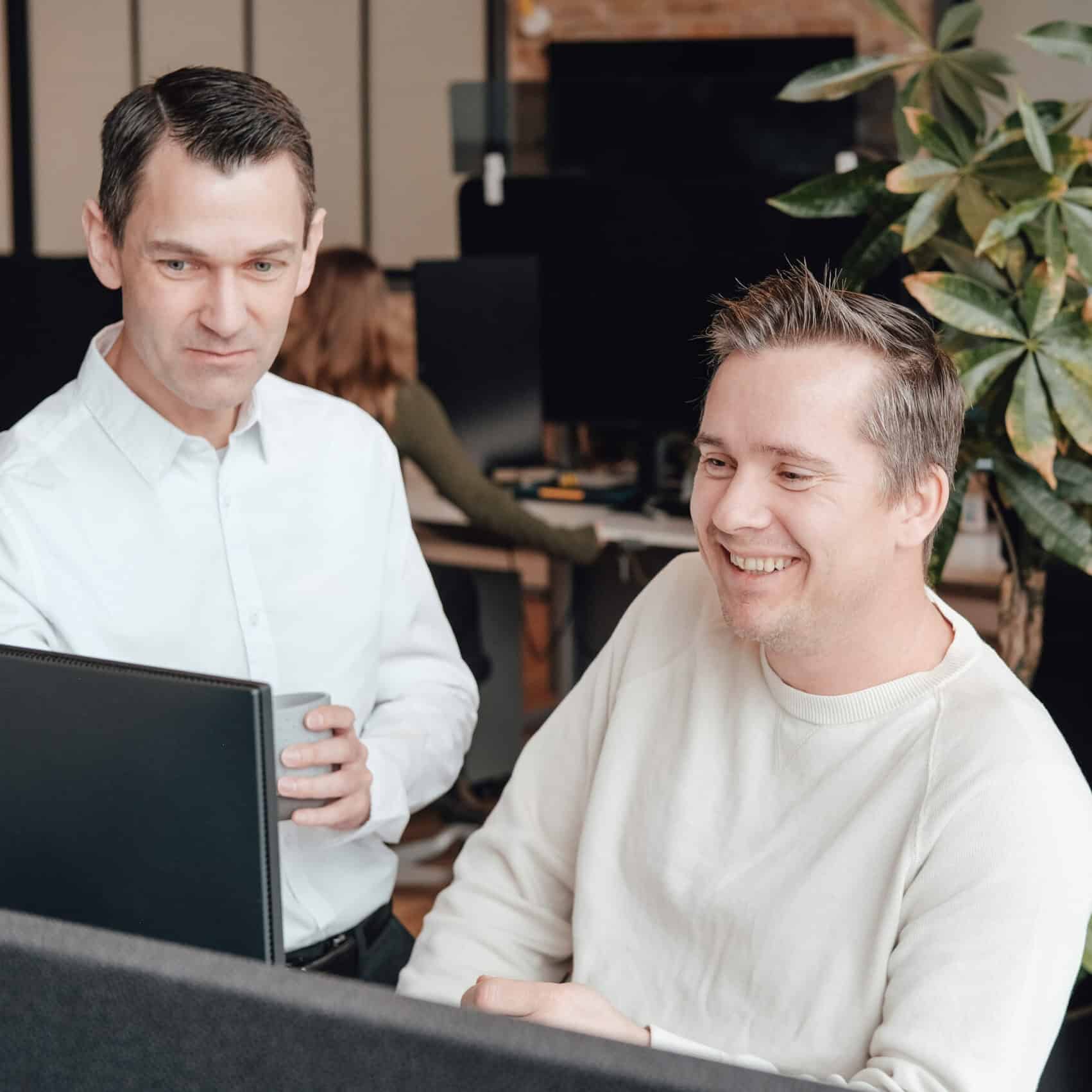 Colleagues at a screen in the Ubivox office